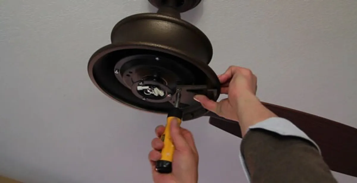 Electrician installing ceiling fan mounting bracket and fixture in Green Bay, WI
