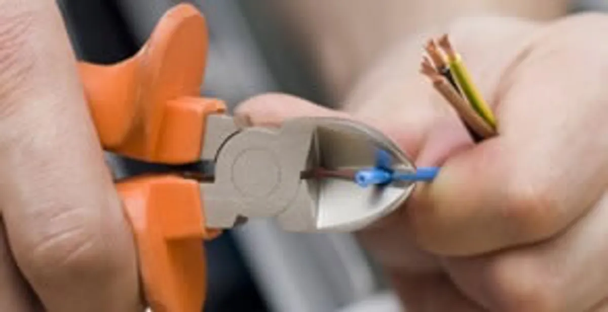 licensed electrician performing precise wire cutting and preparation during electrical service in Green Bay, WI